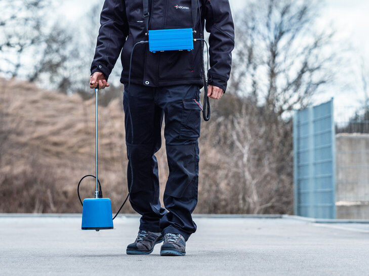 LOCATEC Techniker führt im Außenbereich Messungen zur Leckortung an Versorgungsleitungen durch.